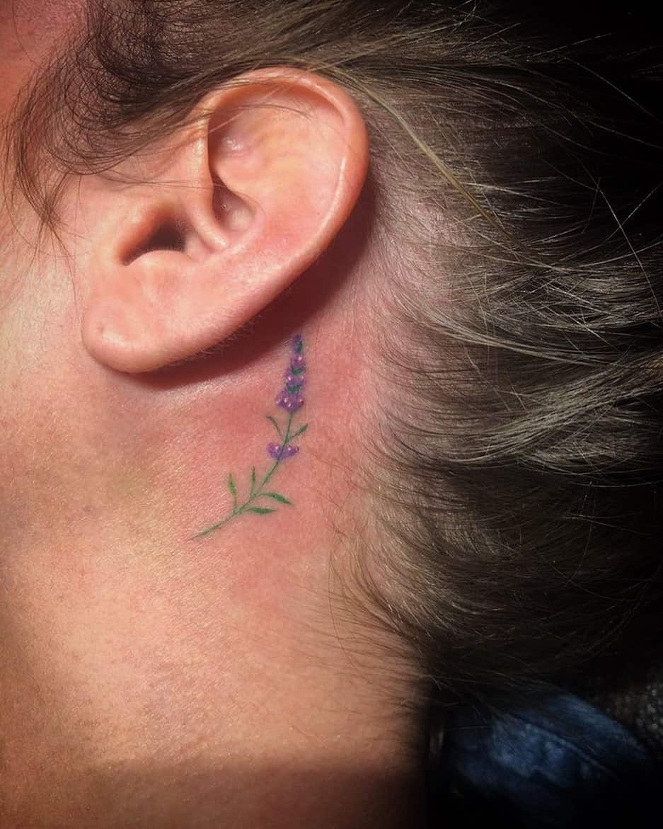 A smal lavender tattoo behind the ear
