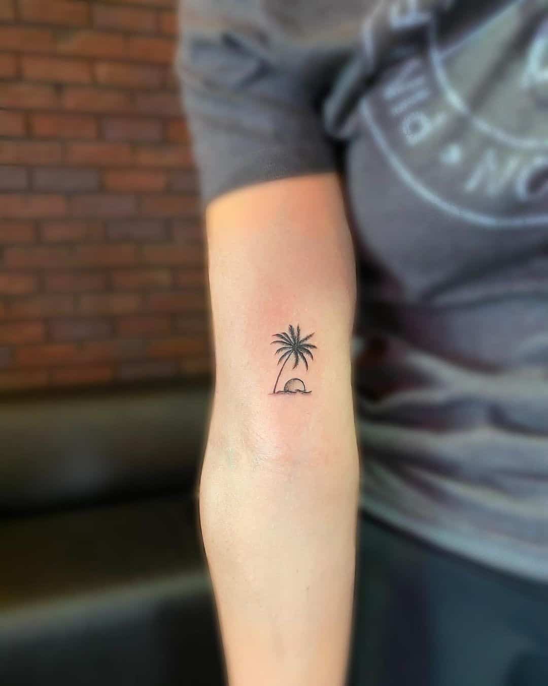 Fine line palm tree tattoo on the wrist