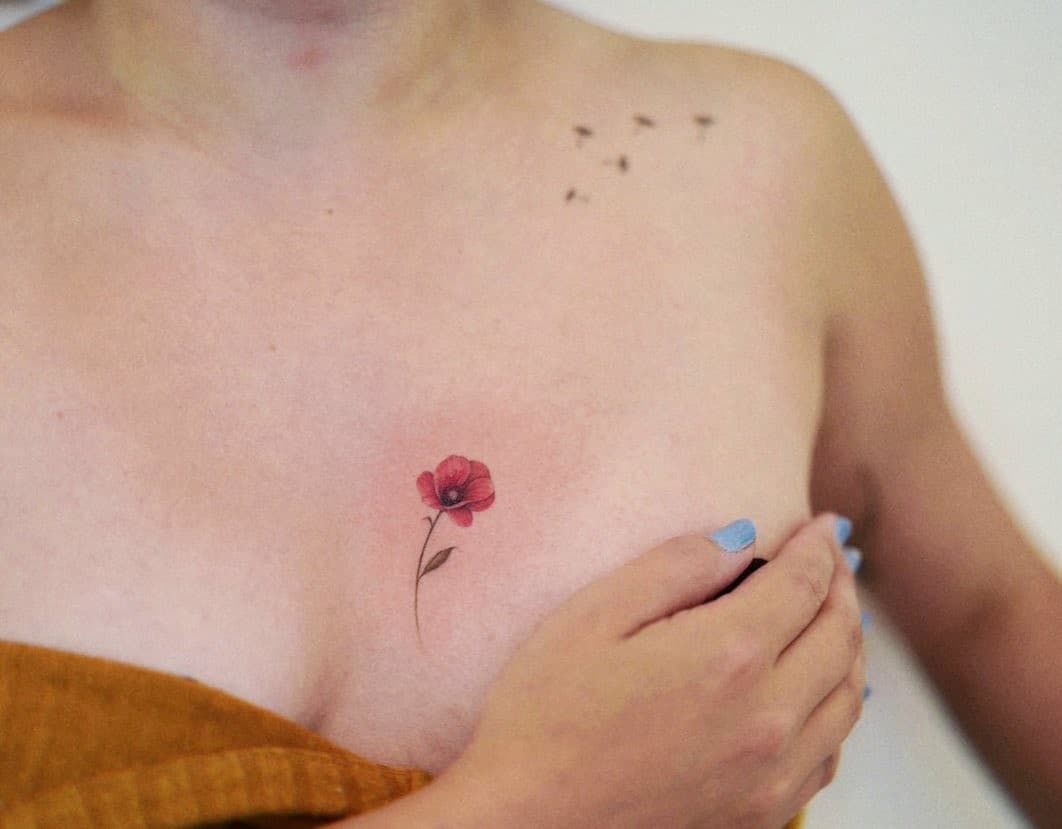 Small Tiny Red Flower Tattoo Over Chest