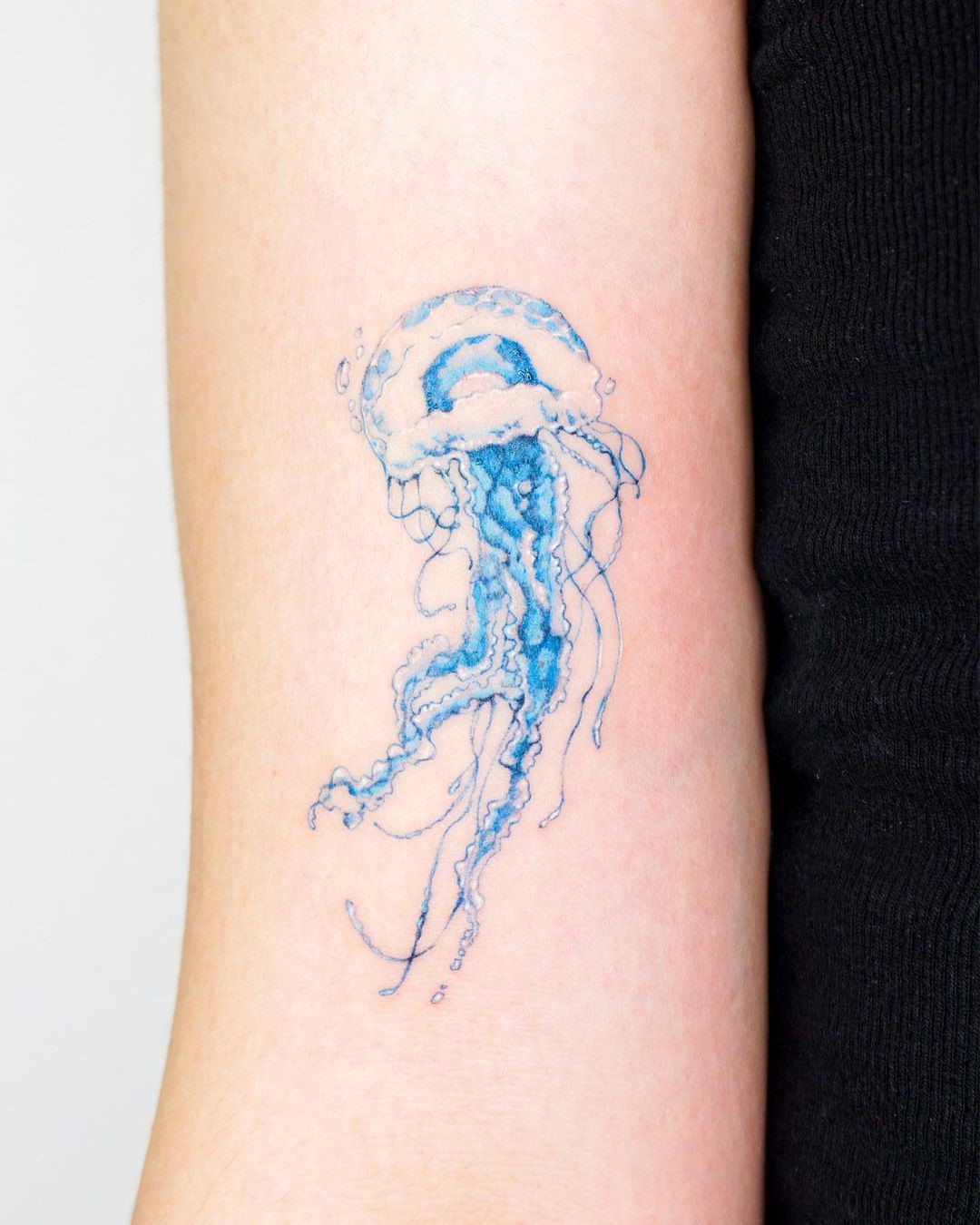 Small Blue Jellyfish Form Wave Tattoo 