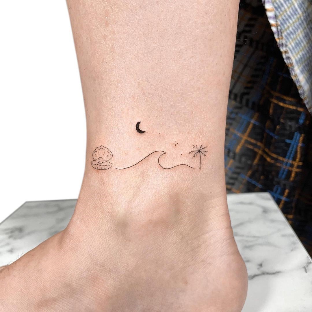 Tiny minimalist wave tattoo on the ankle